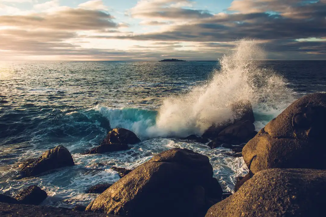 image of waves crashing over big rocks 