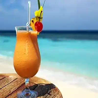 Picture of fruity cocktail on a small table near the surf of cedar key resort